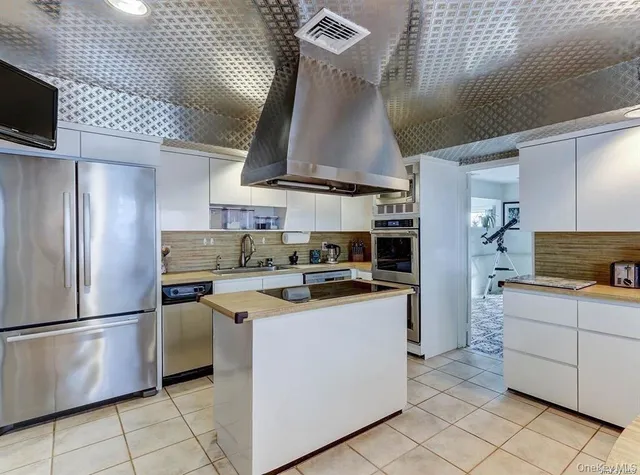 a kitchen with stainless steel appliances granite countertop a sink a stove and a refrigerator
