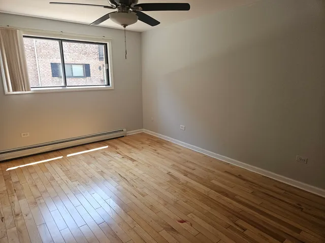a view of empty room with wooden floor
