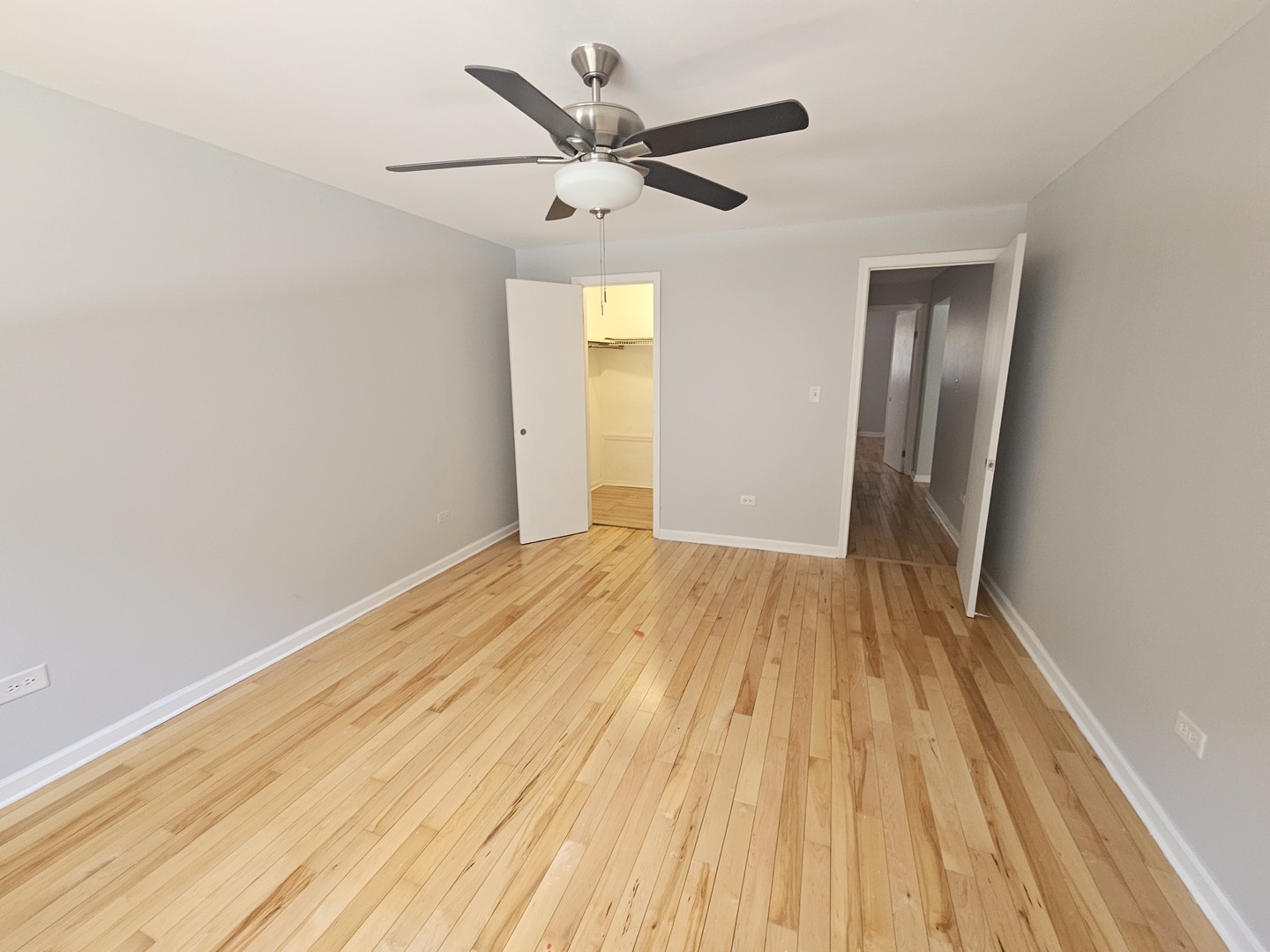 5349 North Delphia Avenue, Unit 150 Chicago, IL 60656 - Photo 10 of 16 a view of a big room with wooden floor and a ceiling fan