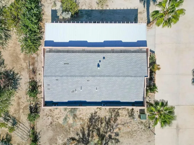 a front view of a house with palm trees