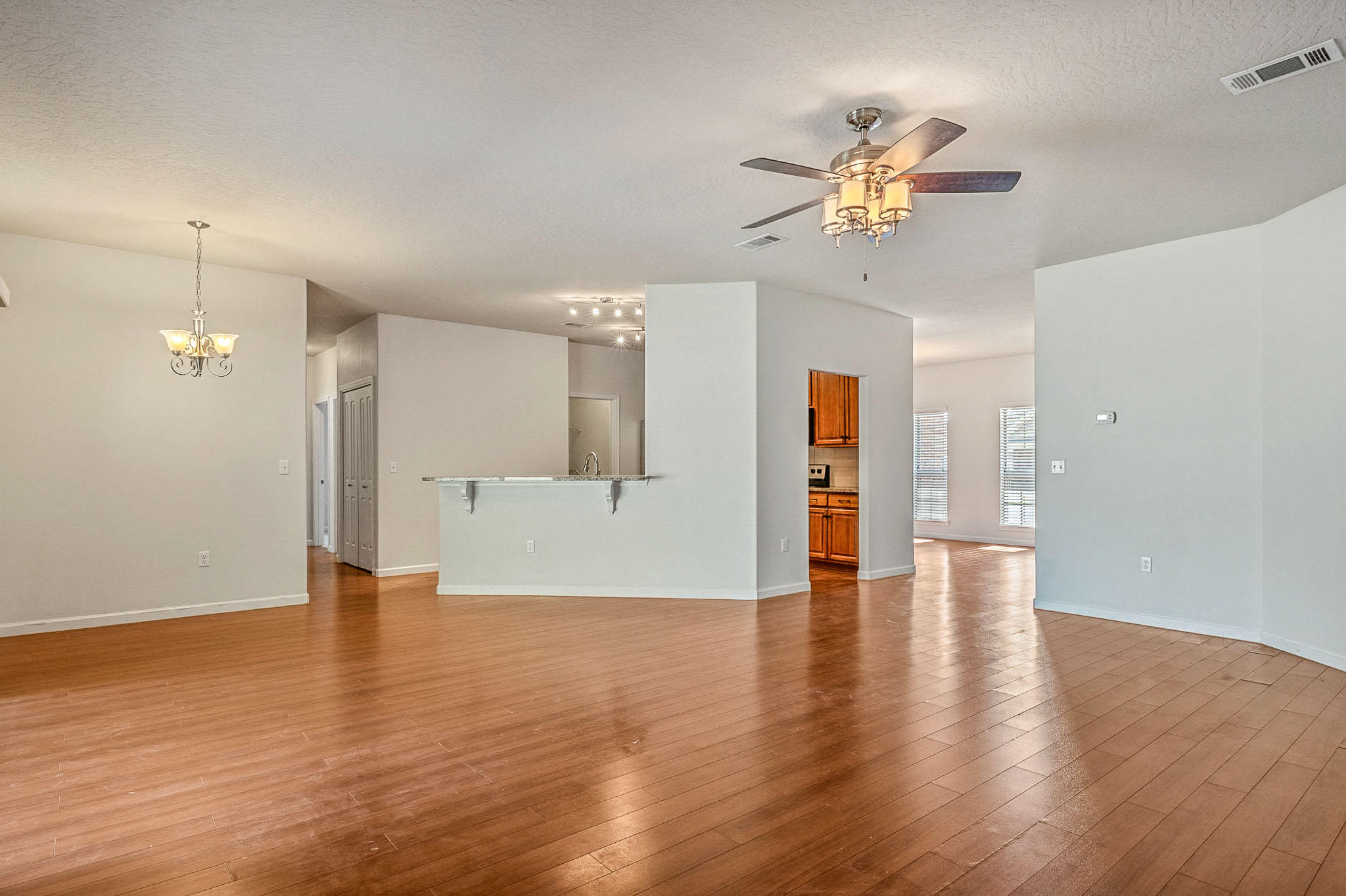 4592 Hermosa Road Crestview, FL 32539 - Photo 4 of 32 a view of an empty room with wooden floor and a ceiling fan