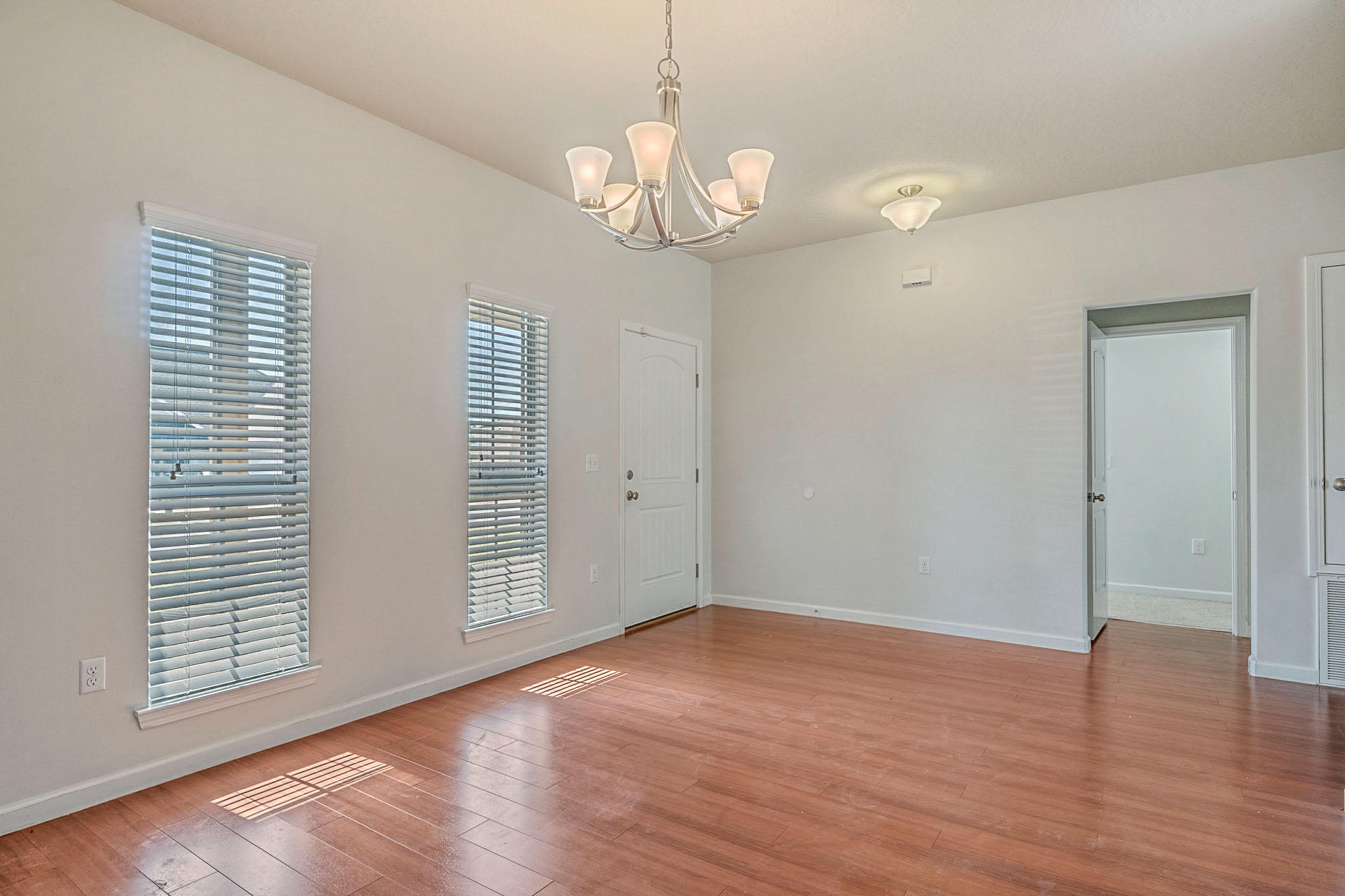 4592 Hermosa Road Crestview, FL 32539 - Photo 6 of 32 an empty room with wooden floor chandelier and windows