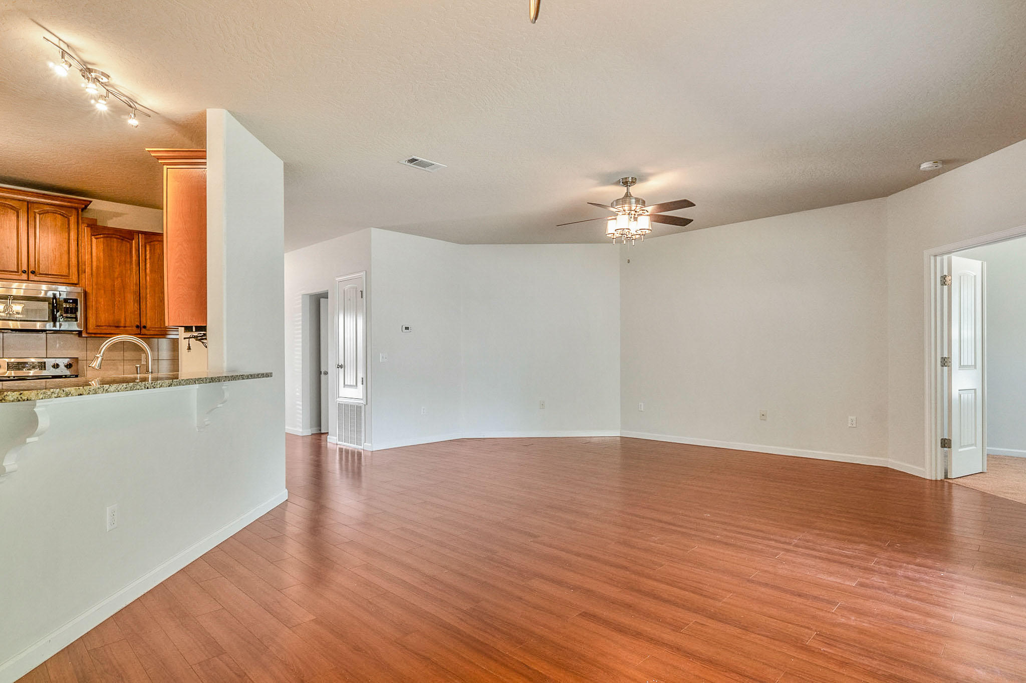 4592 Hermosa Road Crestview, FL 32539 - Photo 7 of 32 a view of a big room with wooden floor and a ceiling fan