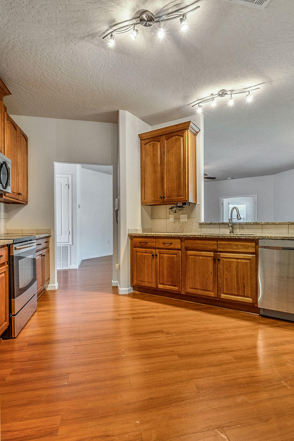 4592 Hermosa Road Crestview, FL 32539 - Photo 10 of 32 a large kitchen with stainless steel appliances a stove a sink and a refrigerator