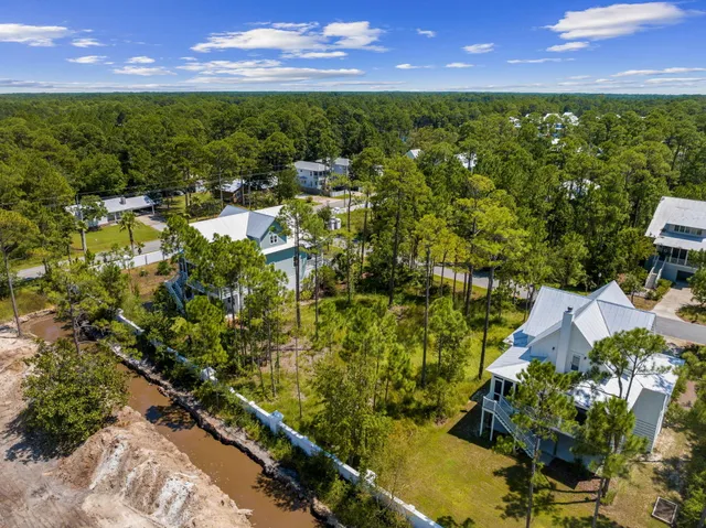 a sign of golf club on a wall under a tree