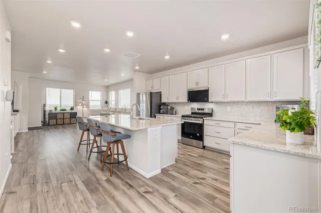 a kitchen with white cabinets and appliances
