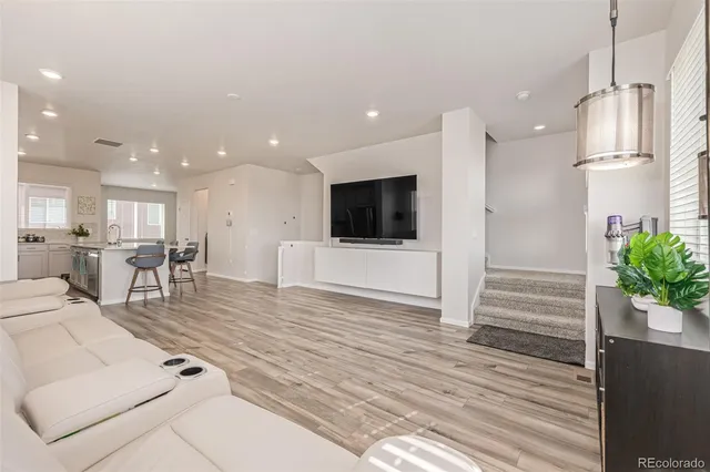 a living room with furniture wooden floor and a flat screen tv