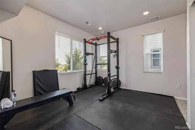 a view of room with gym equipment and windows
