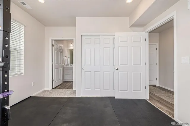 a spacious bedroom with a bed and a dresser