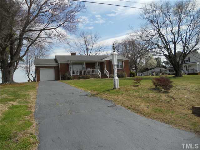 a view of a house with a yard and large tree