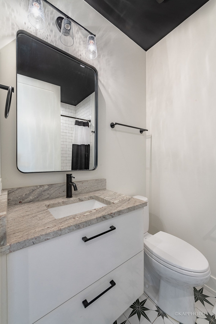 15 North Ada Street Chicago, IL 60607 - Photo 21 of 41 a bathroom with a granite countertop sink toilet and mirror