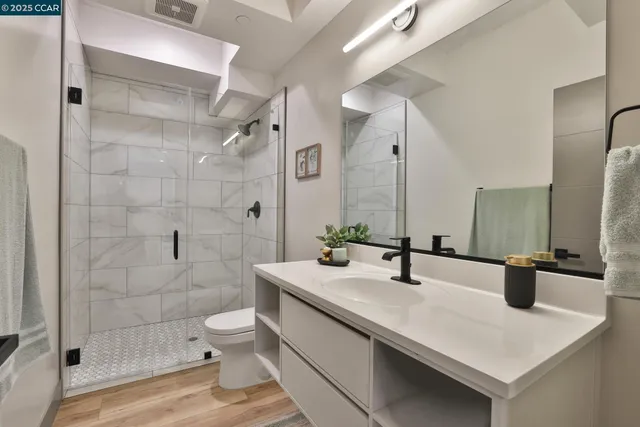a bathroom with a sink a toilet and shower