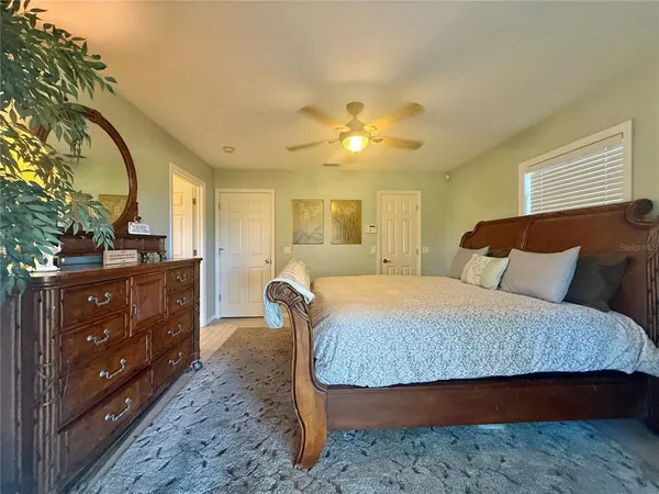 a bedroom with a large bed and a chandelier