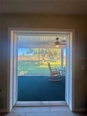 a living room with furniture and a floor to ceiling window