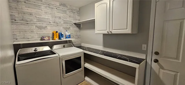 a kitchen with stainless steel appliances granite countertop a refrigerator and white cabinets
