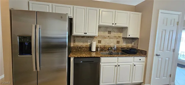 a kitchen with stainless steel appliances granite countertop a refrigerator and a stove