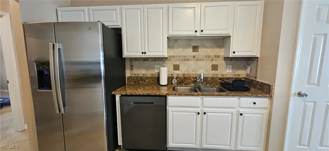 a kitchen with stainless steel appliances granite countertop a refrigerator and a stove