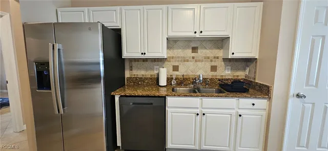 a kitchen with granite countertop a refrigerator stove and sink