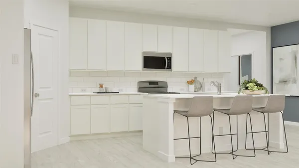 a kitchen with stainless steel appliances granite countertop white cabinets and a refrigerator