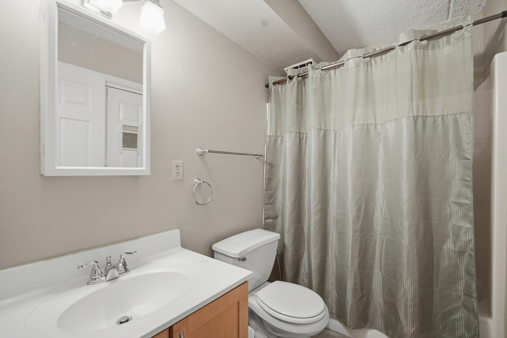 36 Maple Crest Circle, Unit F Holyoke, MA 01040 - Photo 11 of 16 a bathroom with a sink a toilet and shower curtain
