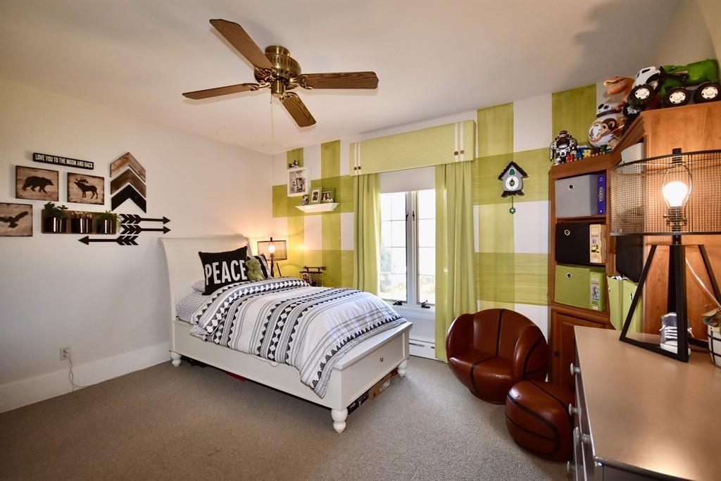 86 Snipatuit Road Rochester, MA 02770 - Photo 25 of 36 a bedroom with a bed a couch and a chandelier