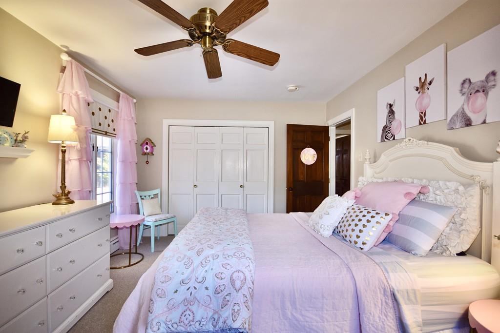 86 Snipatuit Road Rochester, MA 02770 - Photo 27 of 36 a bedroom with a large bed and a chandelier
