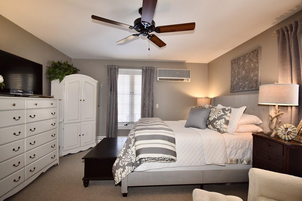 86 Snipatuit Road Rochester, MA 02770 - Photo 30 of 36 a bedroom with a bed a flat screen tv and a couch