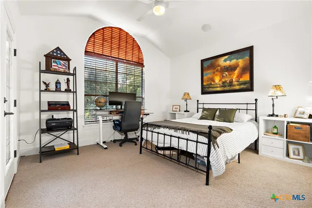a bedroom with a bed a large window and book shelf