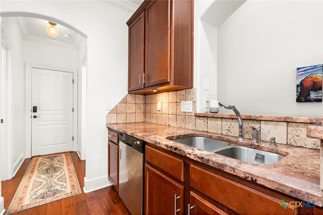 a kitchen with stainless steel appliances granite countertop a sink and wooden cabinets