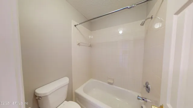 a view of a kitchen with white cabinets and entryway