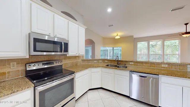 a view of a kitchen with a sink and a ceiling fan