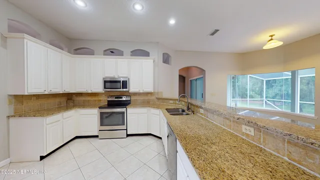 a view of an empty room with wooden floor and a fireplace
