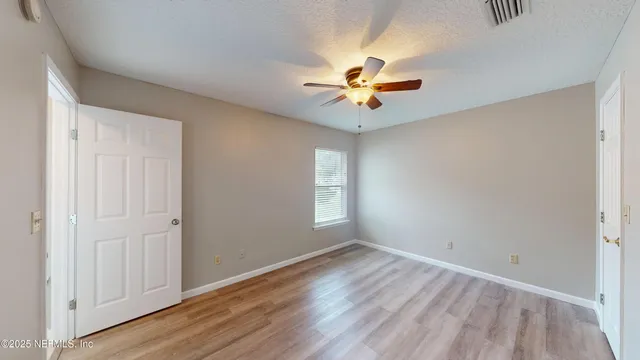 a sign that is sitting in front of a house with potted plants
