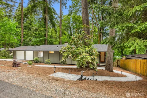 a front view of a house with a yard and trees