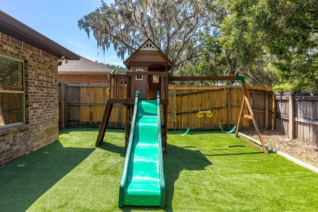a view of a backyard with a slide and a child swing