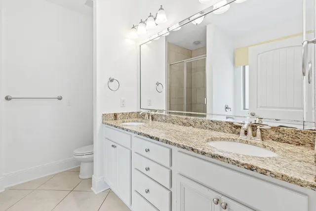 a bathroom with a granite countertop sink a toilet and a mirror