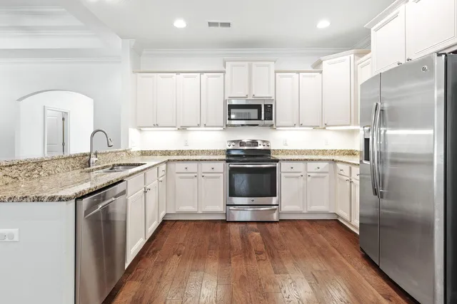a kitchen with stainless steel appliances granite countertop a sink stove and refrigerator