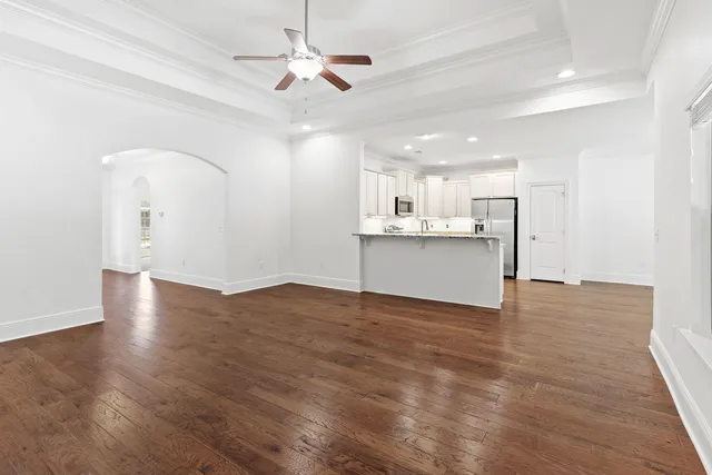 a view of a kitchen with a sink dishwasher a refrigerator with wooden floor and cabinets