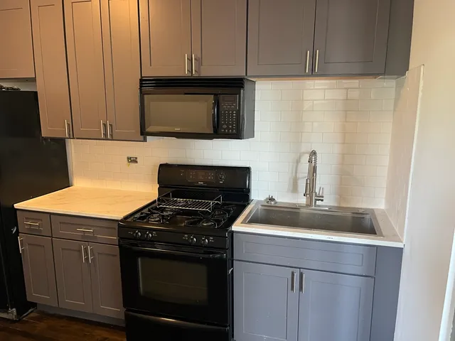 a kitchen with stainless steel appliances wooden cabinets and a stove top oven