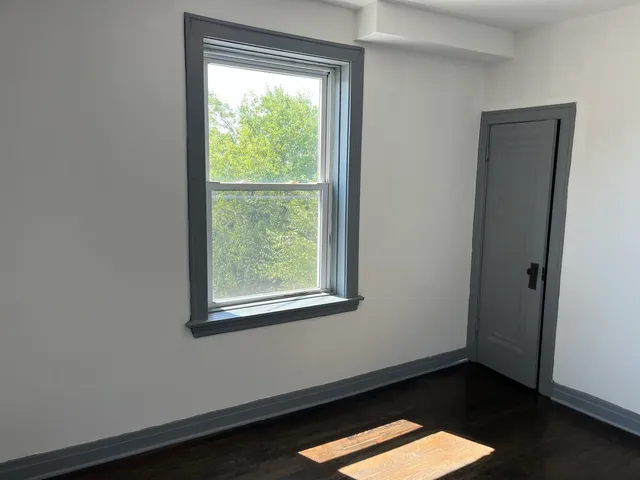 a view of a small space with wooden floor and a window