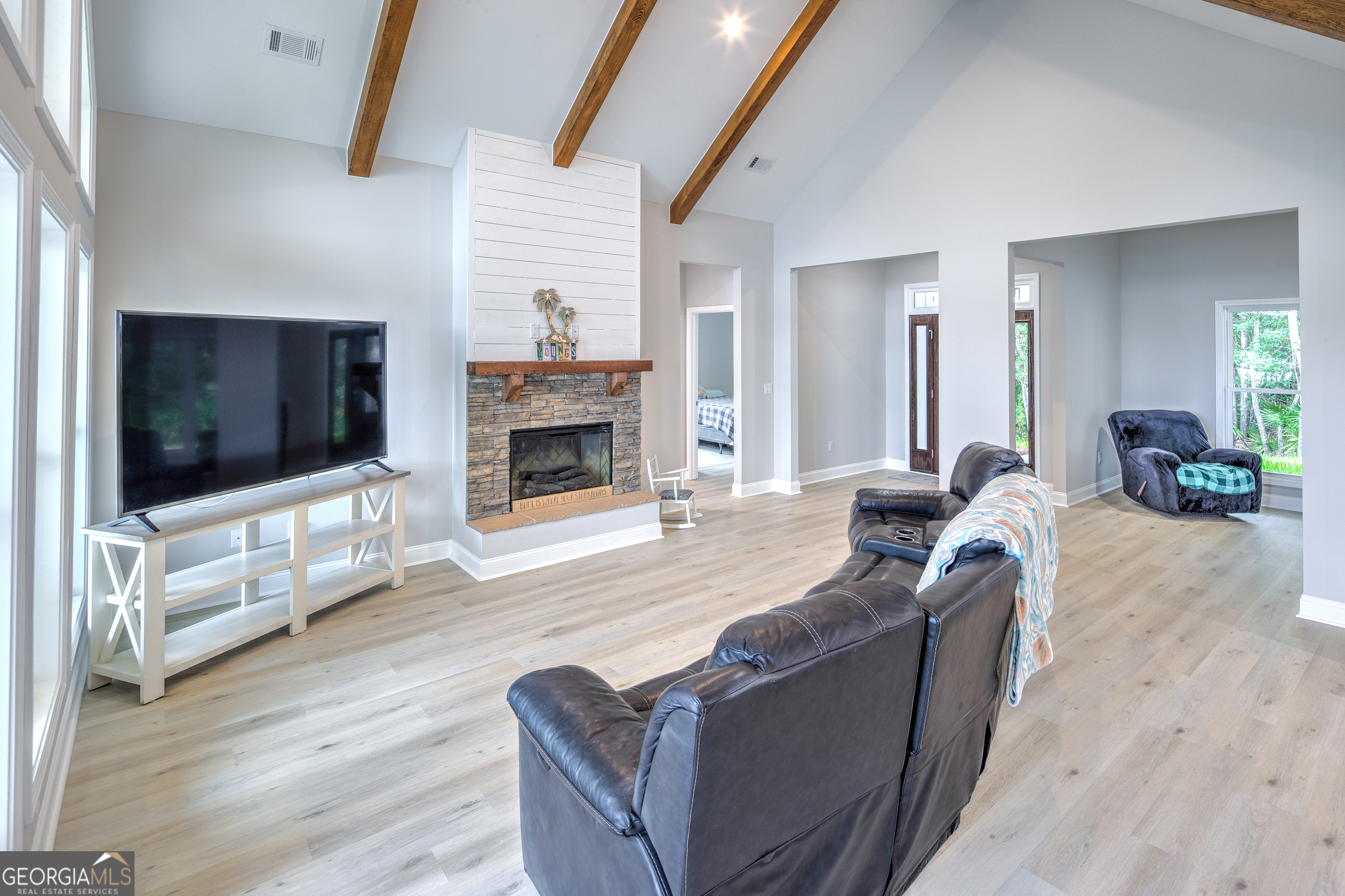 87 Lighthouse Way Woodbine, GA 31569 - Photo 24 of 116 a living room with furniture a flat screen tv and a fireplace
