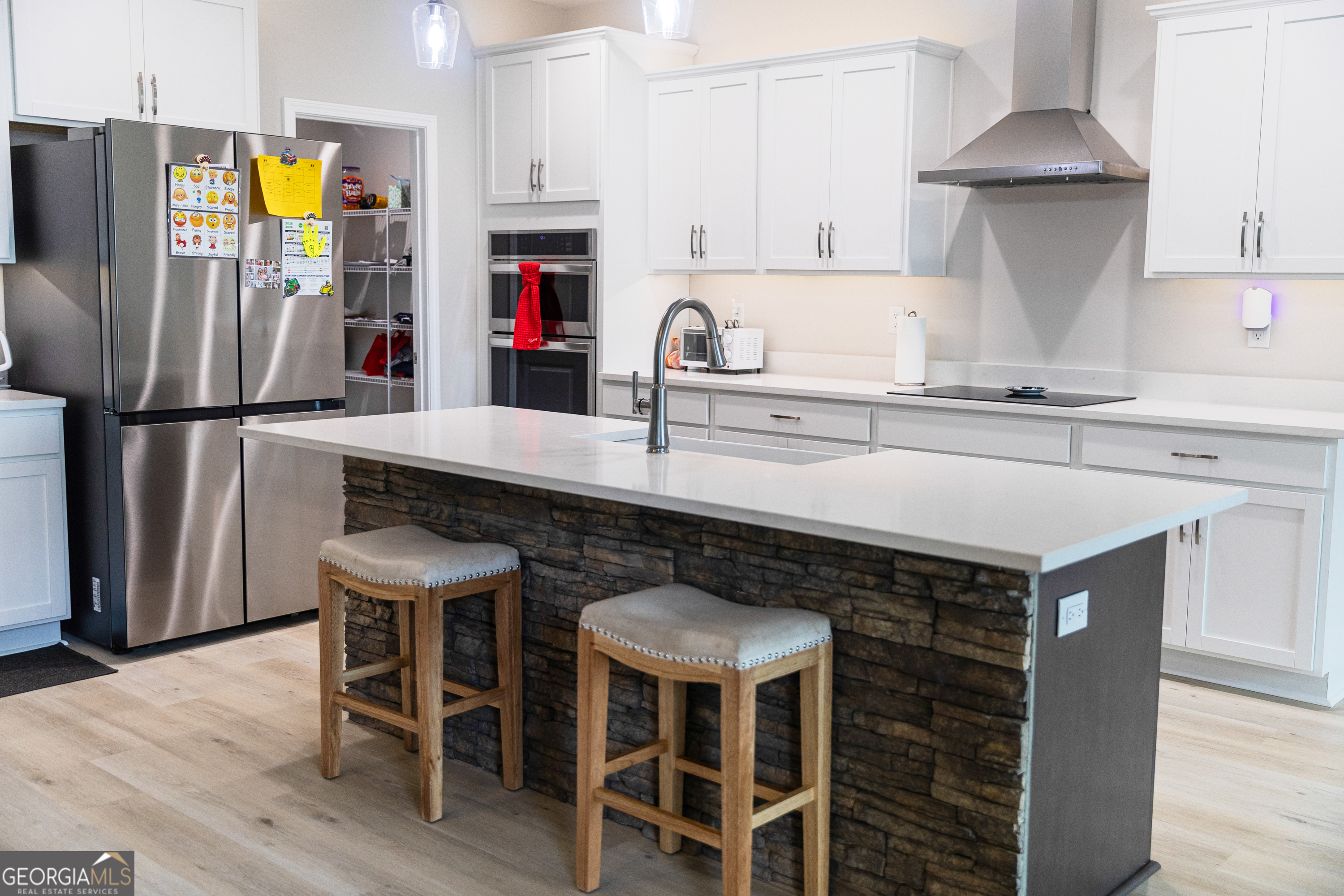 87 Lighthouse Way Woodbine, GA 31569 - Photo 69 of 116 a kitchen with stainless steel appliances granite countertop a table chairs a refrigerator and a sink