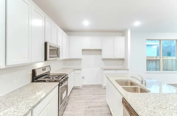 a kitchen with stainless steel appliances granite countertop a sink stove and refrigerator