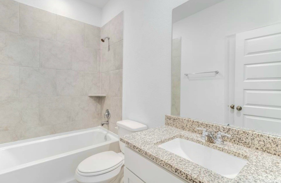 14423 Sunny Bend Way Conroe, TX 77303 - Photo 6 of 9 a bathroom with a granite countertop sink toilet a mirror and bathtub