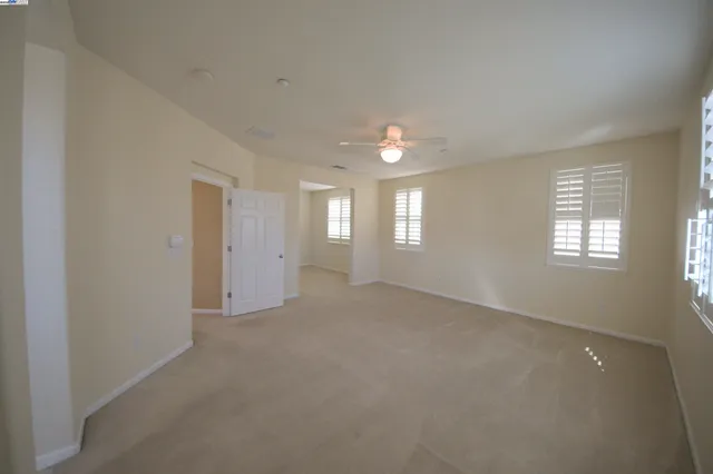 a view of empty room with a ceiling fan and window
