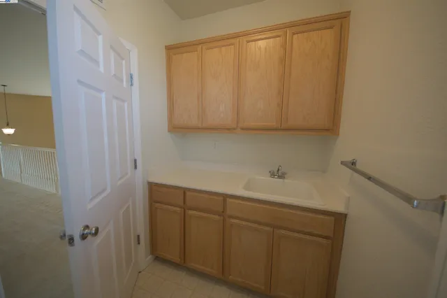 a view of an empty room with windows and chandelier fan