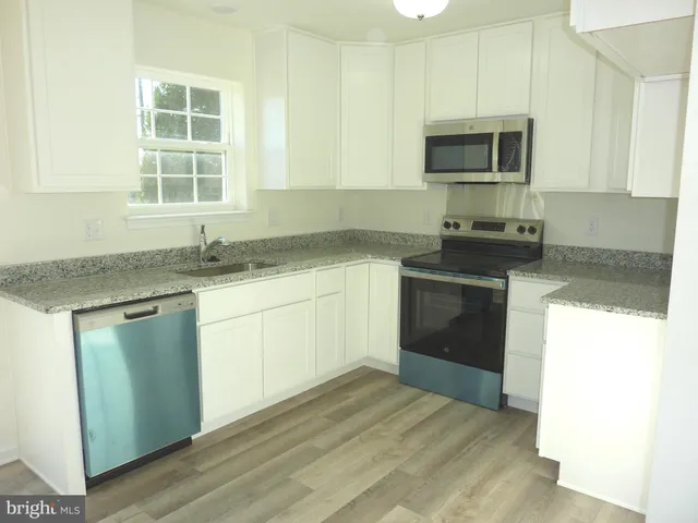a kitchen with a sink stove and microwave