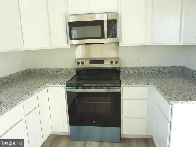 a kitchen with stainless steel appliances granite countertop a stove microwave and sink