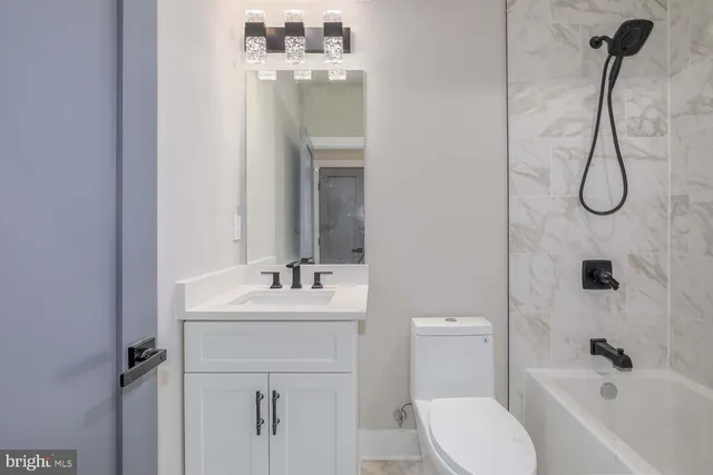 a bathroom with a sink vanity mirror and toilet