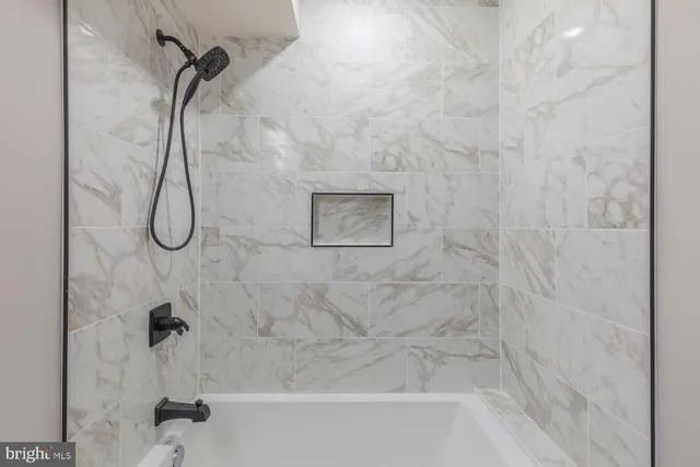 a bathroom with a bath tub with a shower